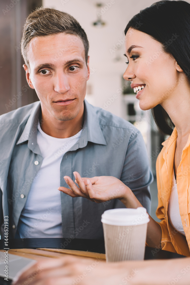 Couple drinking coffee and having discussion using laptop