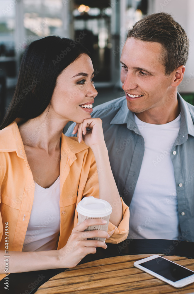 Happy couple sitting at table on date talking