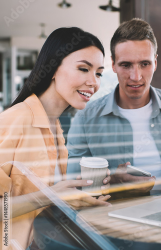 Couple surfing laptop in cafe having discussion