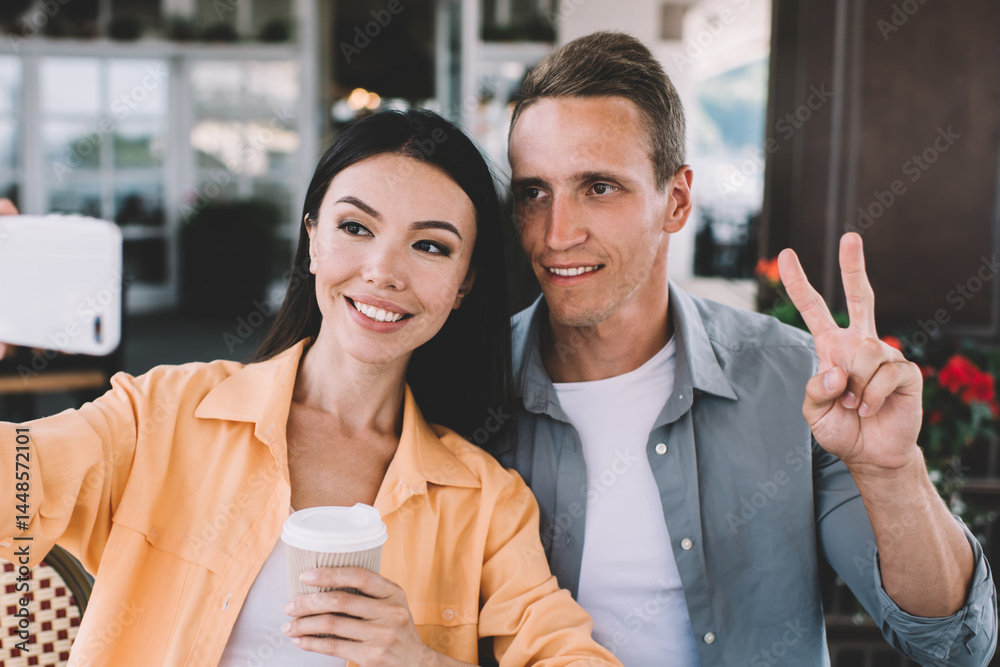 Cheerful couple taking selfie with takeaway coffee