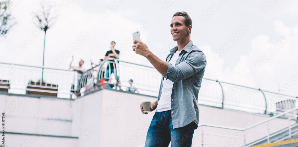 Smiling man using smartphone in city