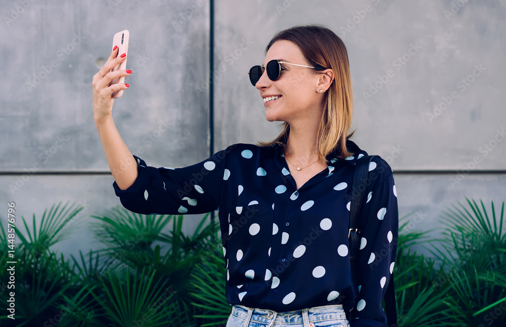 Cheerful woman taking selfie near plants