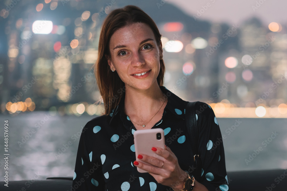 Happy female browsing smartphone on seafront on sunset