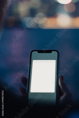 Obraz na płótnie Smartphone with copy space screen in hand of unrecognizable woman on blurred background of night river and city w salonie