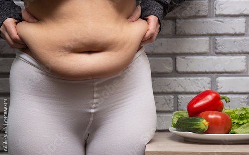 Close up of overweight young woman with fat belly after childbirth