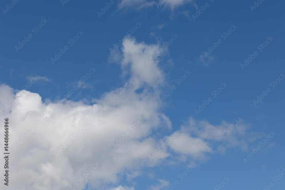 White clouds drifting across a vibrant blue sky White clouds drifting across a vibrant blue sky