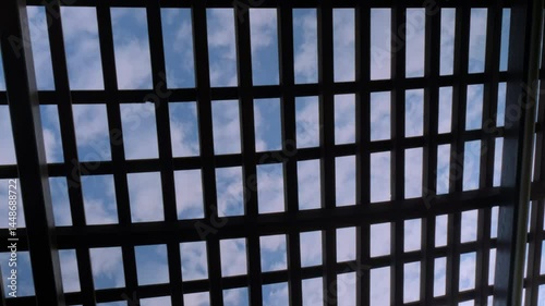Wallpaper Mural Time lapse: quickly shifting white clouds seen through simple wooden lattice decoration in park - bottom up view. Architecture, nature, and timelapse concept Torontodigital.ca