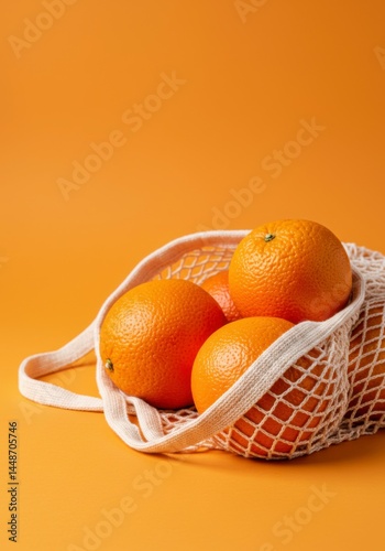 Zero waste shopping concept with oranges in eco-friendly net bag on orange background.