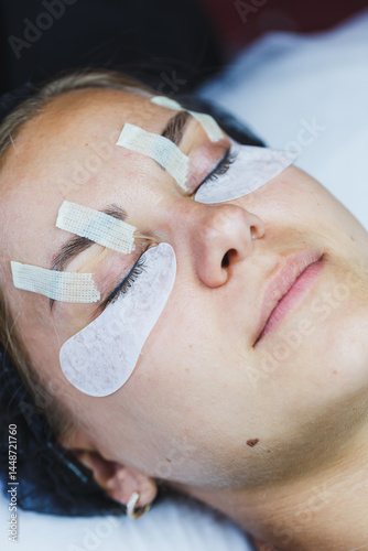 Obraz na płótnie Eyelash gluing method. Close-up of a woman's face during the procedure of Botox lamination of eyelashes. Eyelash care: lifting and curling, lamination and eyelash extensions. w salonie