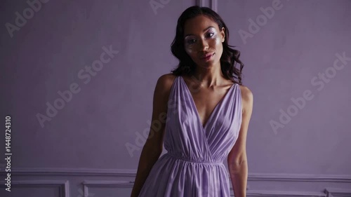 Elegant woman in lilac dress standing in classic interior setting