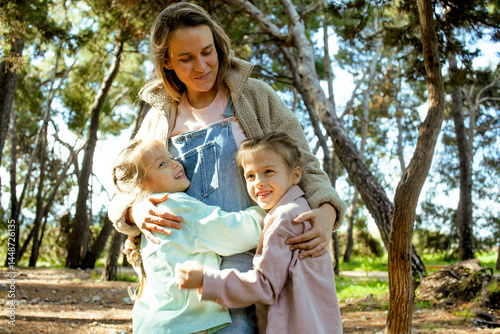 young mother with twins daughters outside having fun