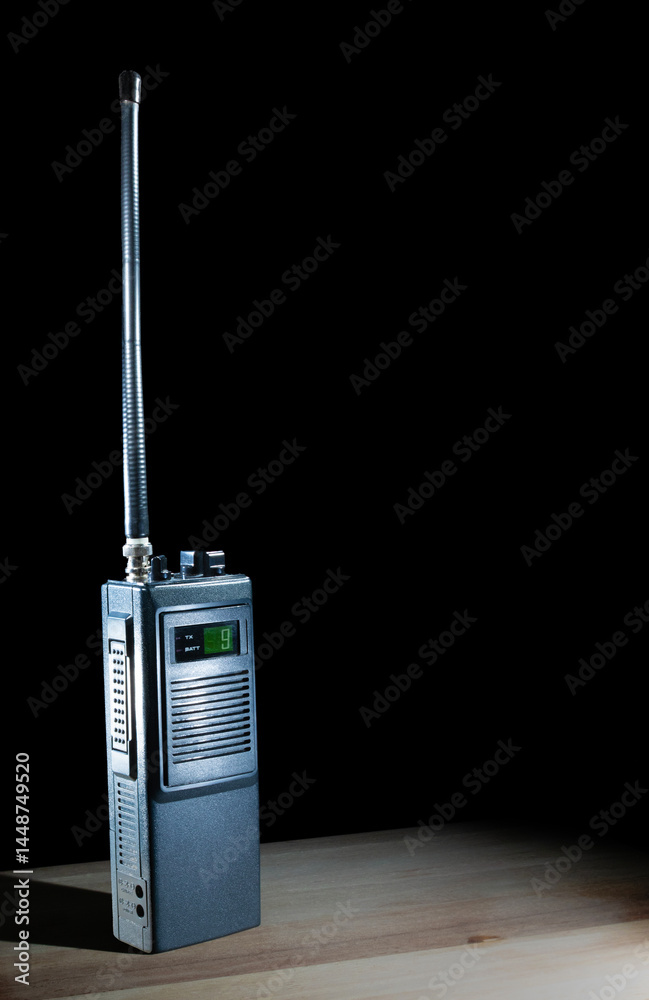 Walkie-talkie on a table set to channel nine with a black background