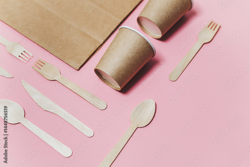 Flat lay composition with eco friendly paper disposable tableware on pink background