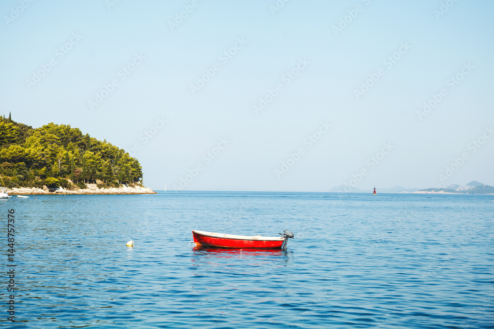 A Serene Red Boat Float Gracefully on Calm Waters Surrounded by Natures Beauty and Peace