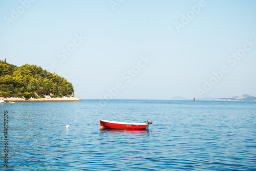Obraz na płótnie A Serene Red Boat Float Gracefully on Calm Waters Surrounded by Natures Beauty and Peace w salonie