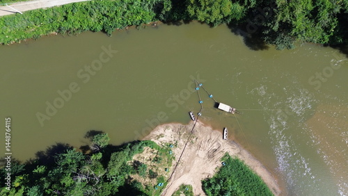 Фотография A extração de areia em leito ativo de um rio com uso de draga instalada em uma balsa, vista com uso de drone
