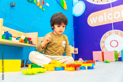 Obraz na płótnie Boy playing with colorful building blocks in playroom w salonie