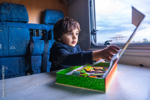 Obraz na płótnie Child playing with puzzle inside a camper van during road trip w salonie