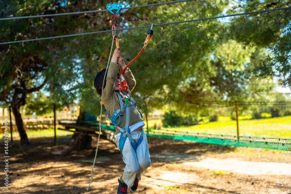 Young boy enjoying zip line adventure in outdoor park
