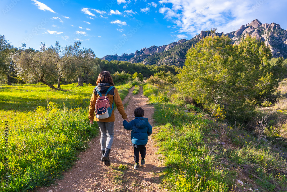 Mother and son hiking in montserrat mountains on sunny day