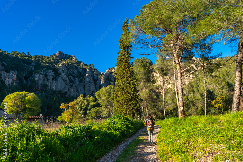 Tourist walking on path near montserrat mountains in catalonia, spain