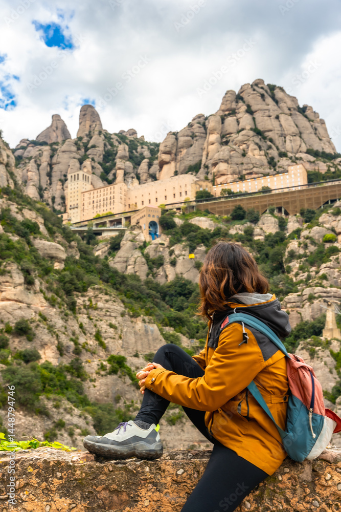 Hiker resting and admiring the montserrat monastery in catalonia, spain