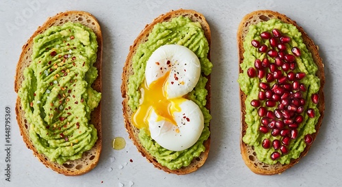 Three avocado toast styles: classic (salt/chili flakes), with poached eggs, and pomegranate seeds. Toasted artisan bread, overhead flat lay