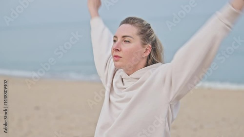 A young woman warming up before sports on a beach. wellness concept