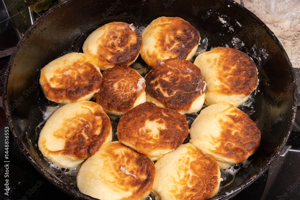 Golden-brown fried bread pieces sizzling in a cast iron skillet