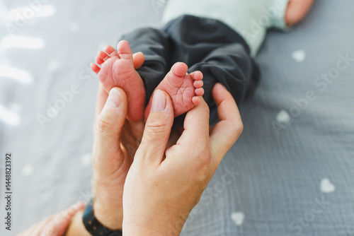 Obraz na płótnie Close-up of baby feet in parent's hands. Baby feet with little toes. Cute photo of baby feet. w salonie