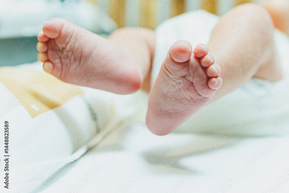Close-up of baby feet in parent's hands. Baby feet with little toes. Cute photo of baby feet.