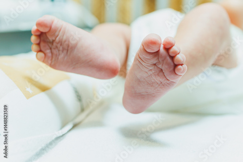 Obraz na płótnie Close-up of baby feet in parent's hands. Baby feet with little toes. Cute photo of baby feet. w salonie