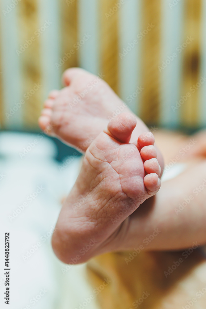 Close-up of baby feet in parent's hands. Baby feet with little toes. Cute photo of baby feet.