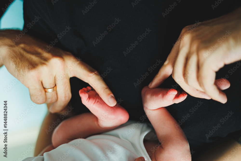 Close-up of baby feet in parent's hands. Baby feet with little toes. Cute photo of baby feet.
