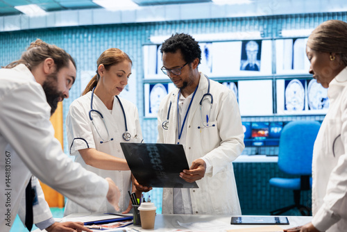 Diverse licensed medics working together to put the right diagnosis after examining x ray test results in medical cabinet. Physicians experts ensuring disease prevention and treatment. photo