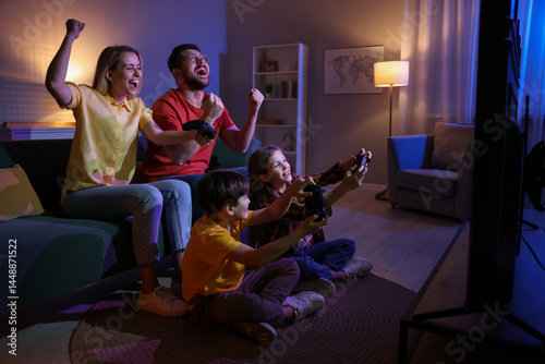 Bild auf Leinwand Happy family playing video games in living room at night