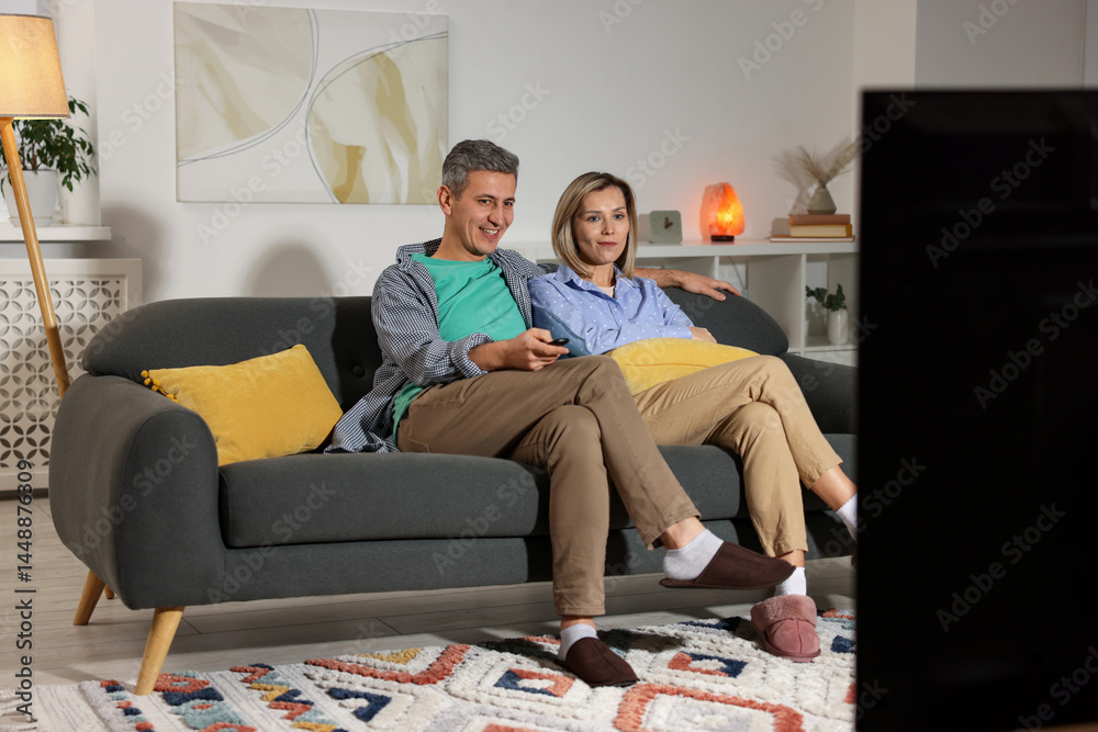 Obraz premium Lovely couple watching TV on sofa at home