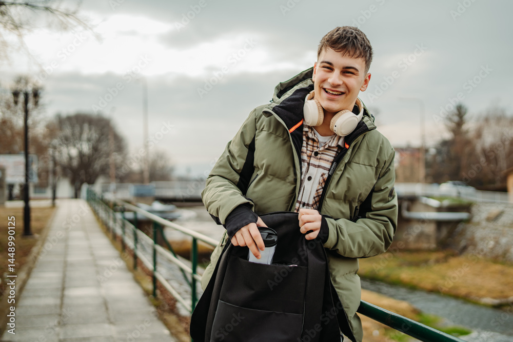 Fototapeta premium Portrait of young adult man student smile and use cellphone 