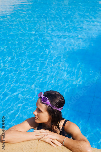 Young Woman Relaxing at the Edge of a Swimming Pool
