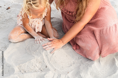 A mom and daughter build sandcastles