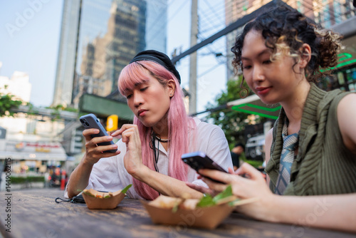 Friends using smartphone while having street food
