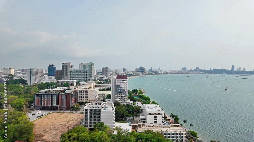 Pattaya city with beach, many boats in the sea and many buildings. It is a landmark and a popular destination.
