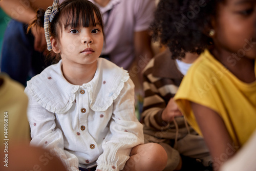 Portrait of serious girl sitting with friends