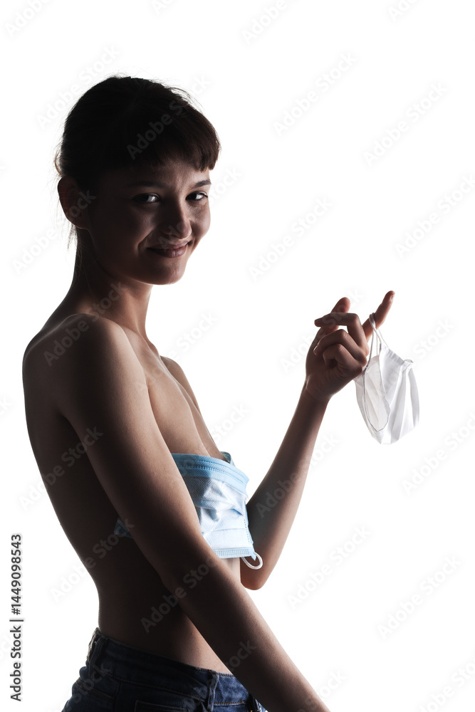 Naklejka premium Young woman removing medical face mask, capturing a sense of relief and freedom