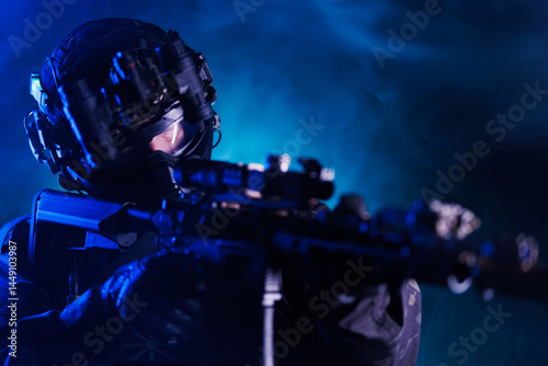 Special forces soldier with rifle equipped for night operations in smoky environment.