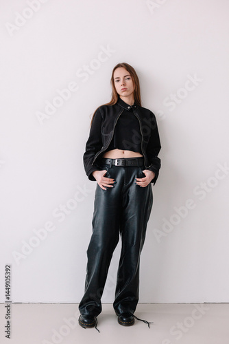 Young woman poses confidently in stylish black outfit