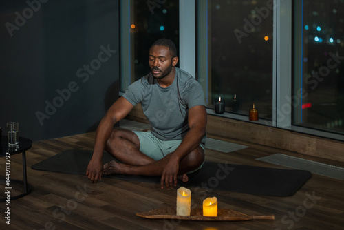 Man Meditating at Night with Candles photo