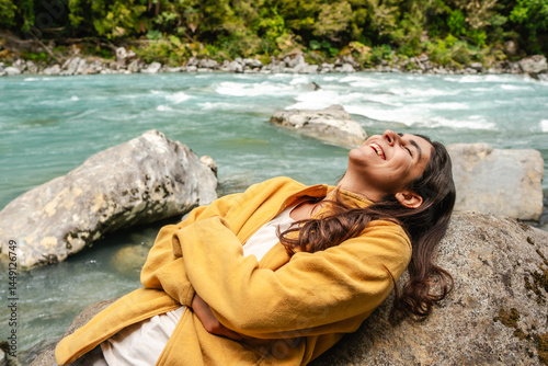  joyful woman relaxes by a  river having a Serene Moment in Nature photo