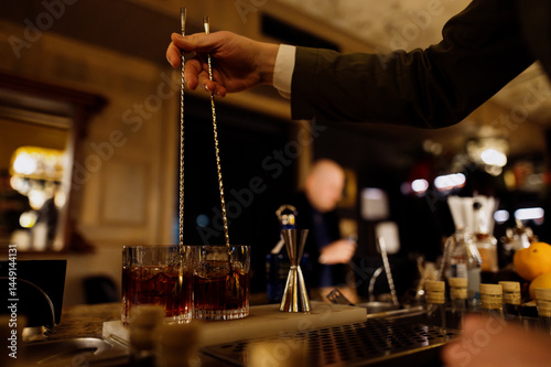 Bartender preparing cocktails in a cozy bar setting
