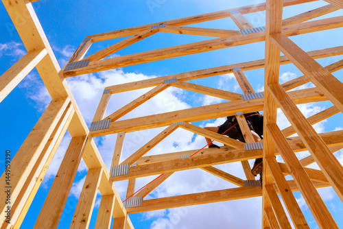 Construction worker engages in building wooden roofing frame structure, utilizing tools